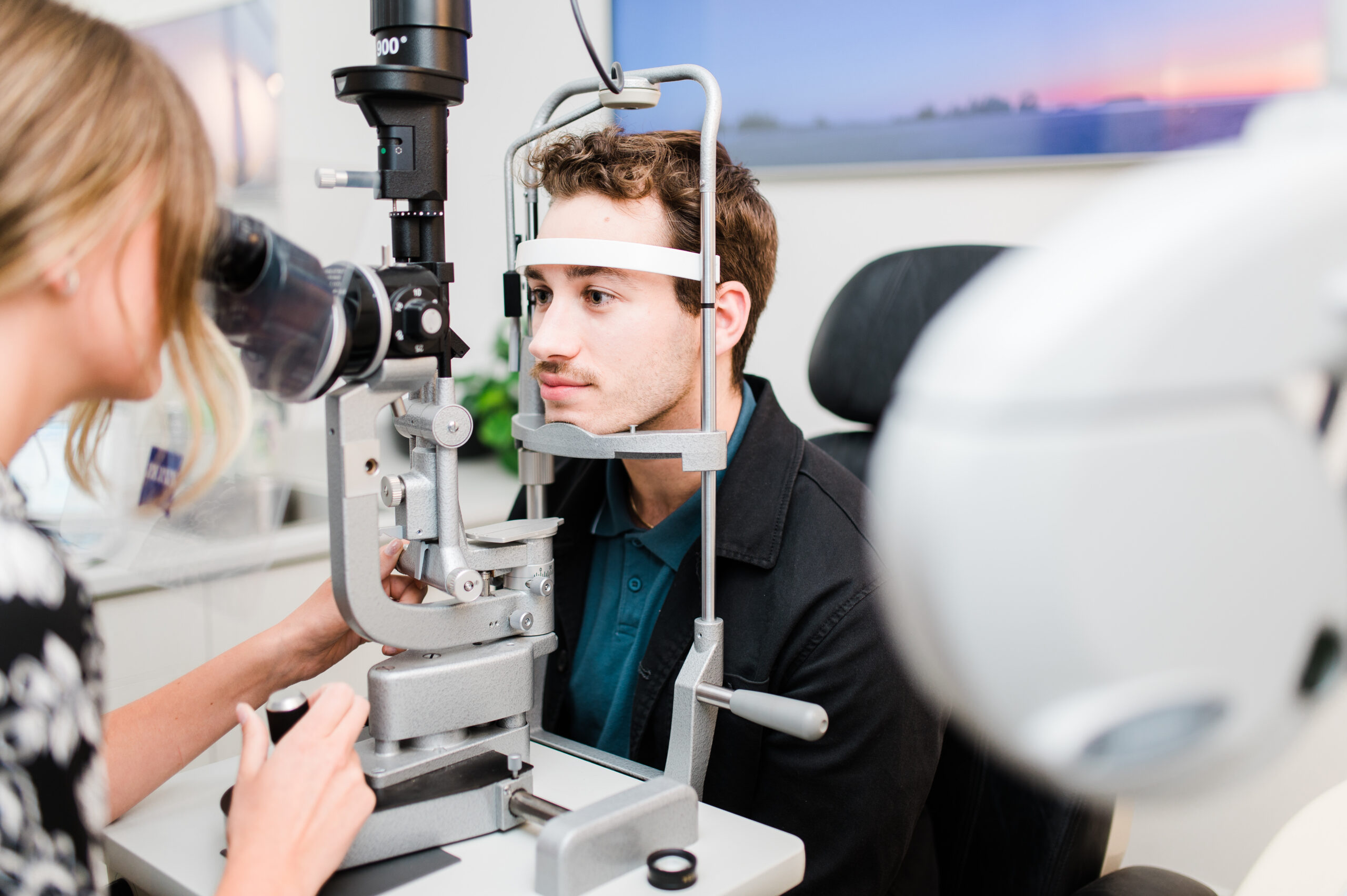 A young man sits with his Kamloops optometrist for a comprehensive eye exam