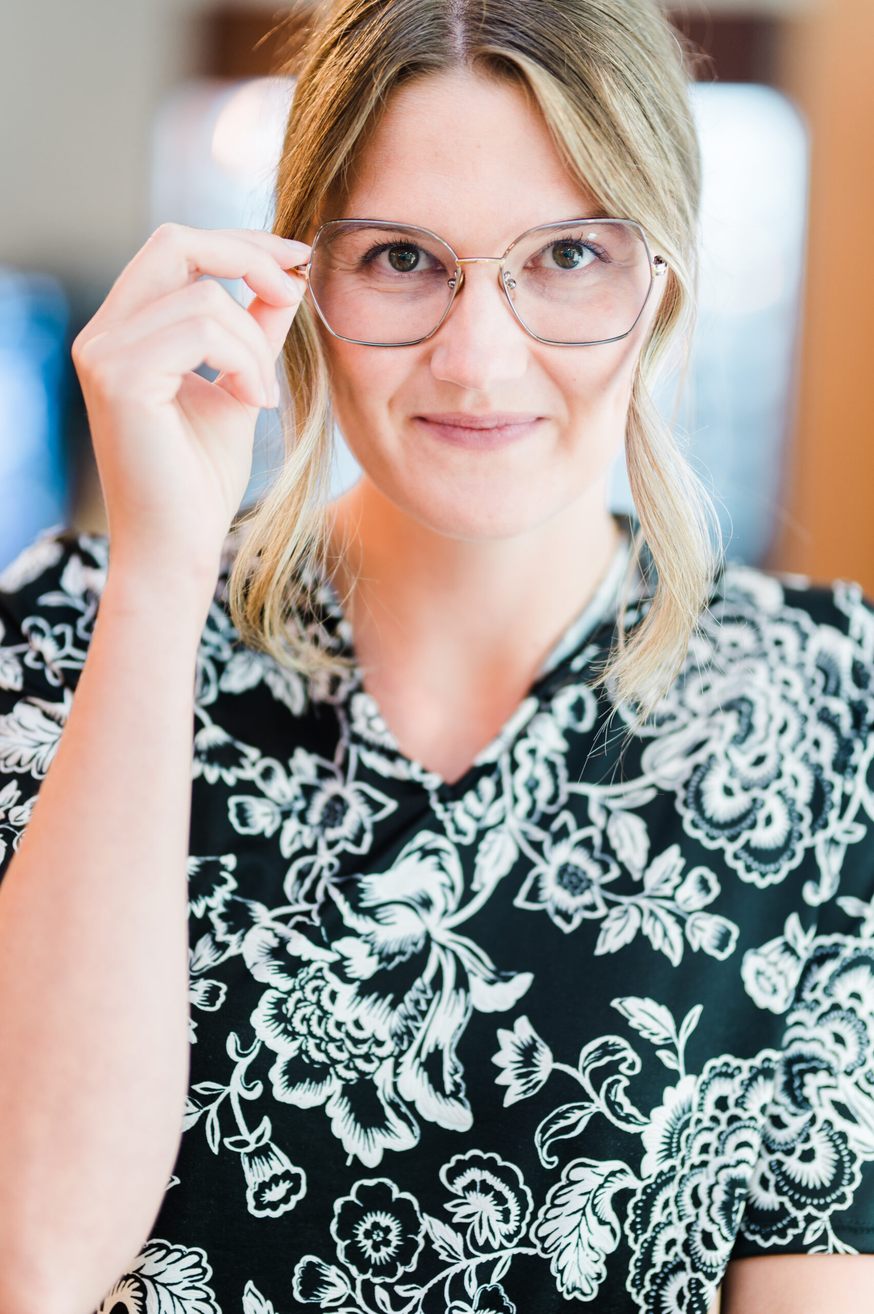 An optometrist in Kamloops poses with her transition lenses to show how they work in sunlight