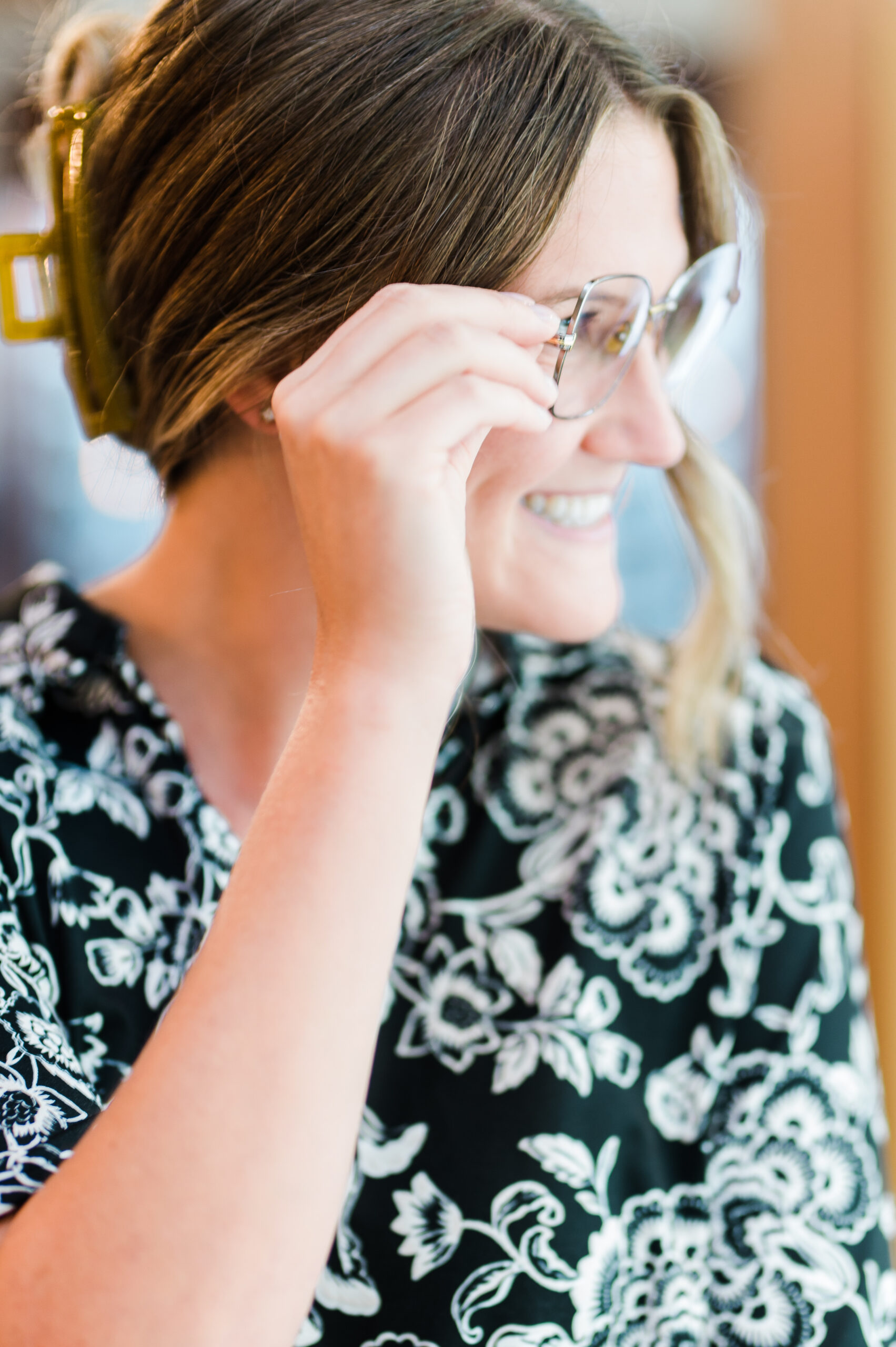 A lady adjusting her eyeglass frames before an eye exam in Kamloops.