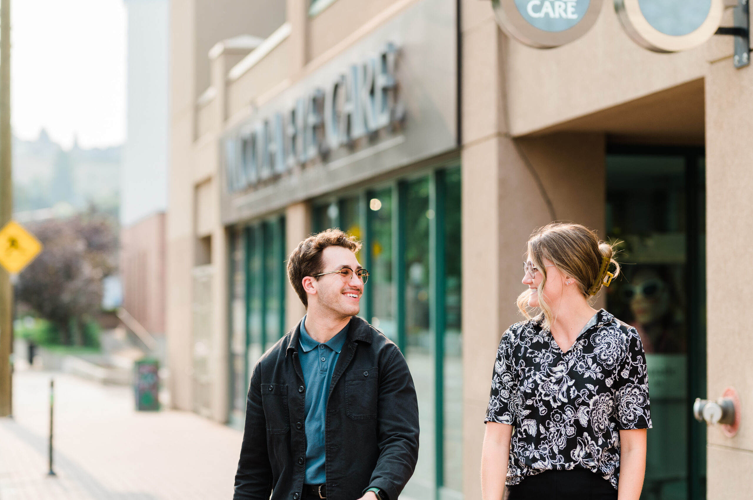 A man and a woman stand smiling outside Nicola Eye Care, a premium eye clinic in Kamloops