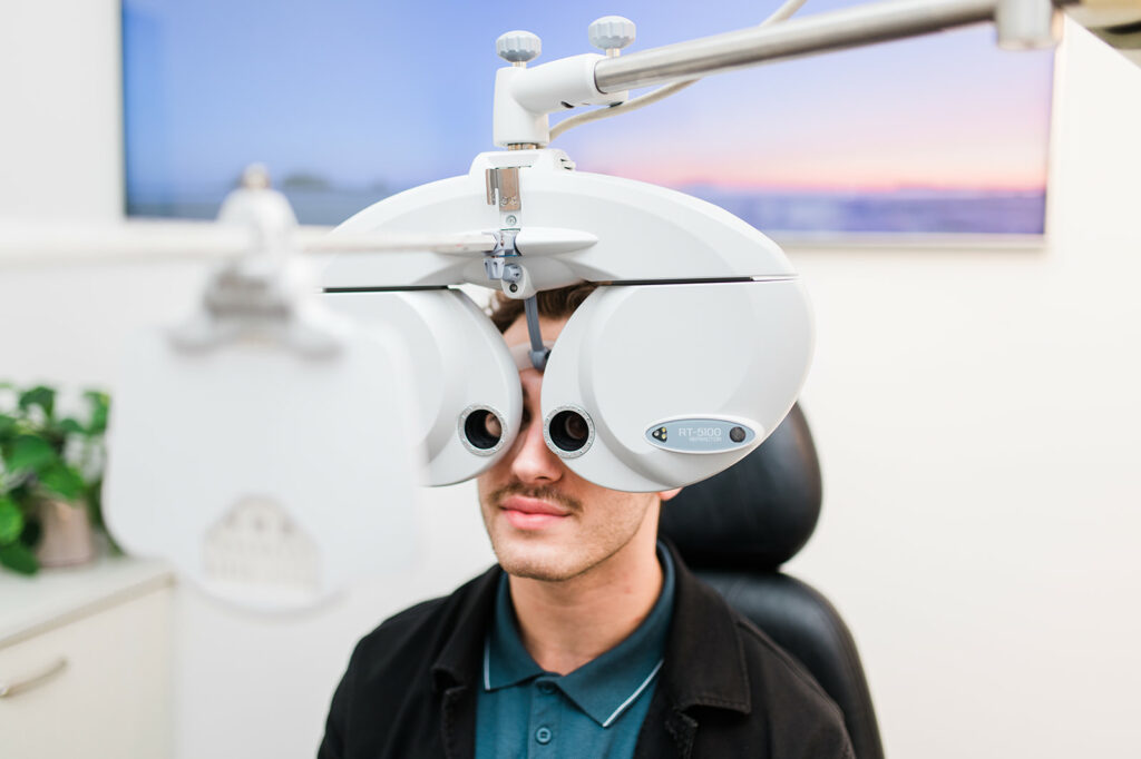 A young man has his eyes checked and identifies letters during his vision test
