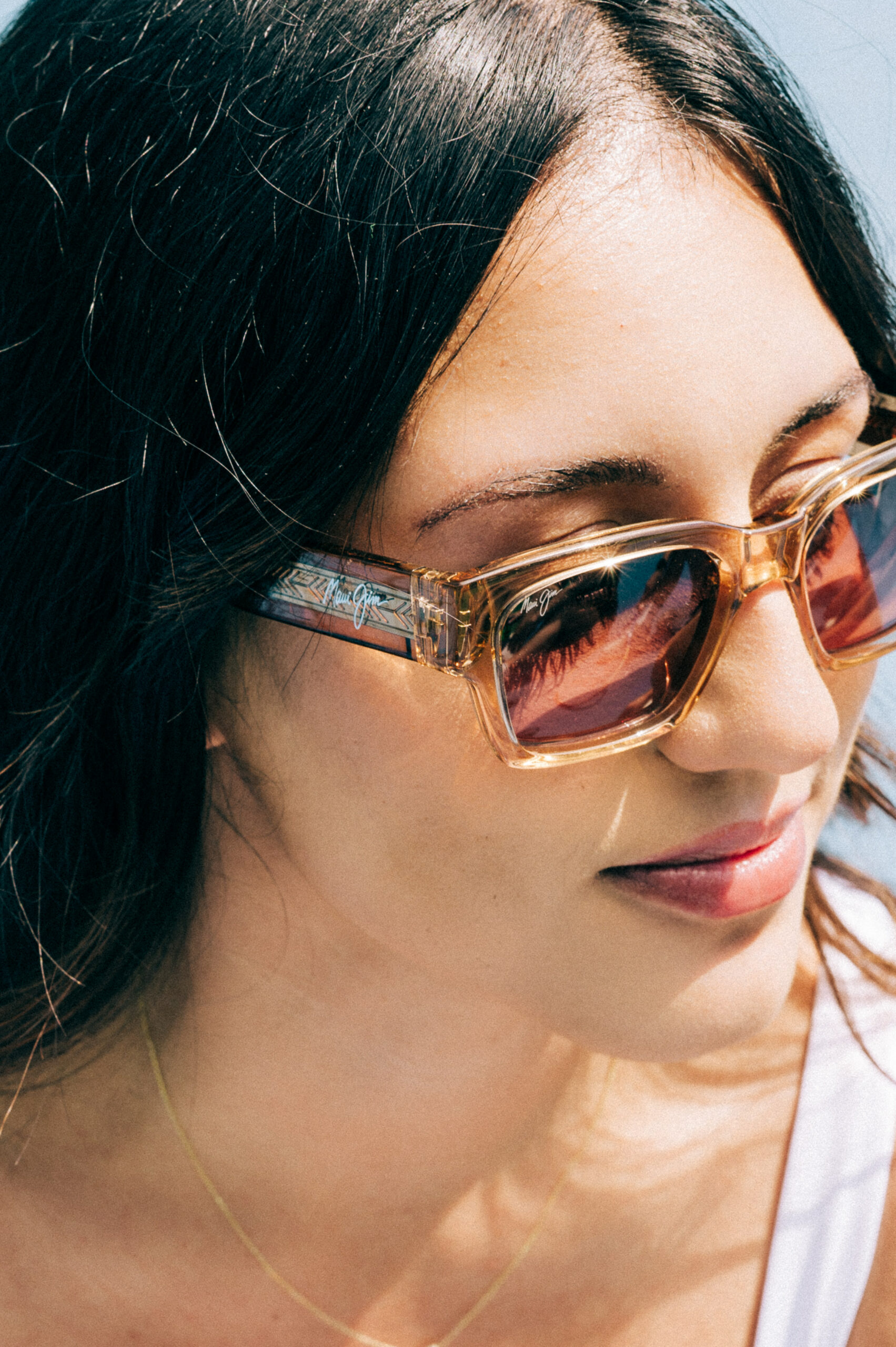 Girl with brown hair wearing Maui Jim sunglasses.