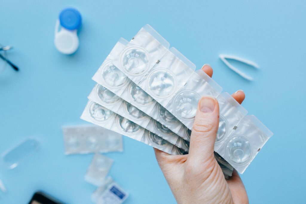 optometry clinic patient holds new contact lens packets