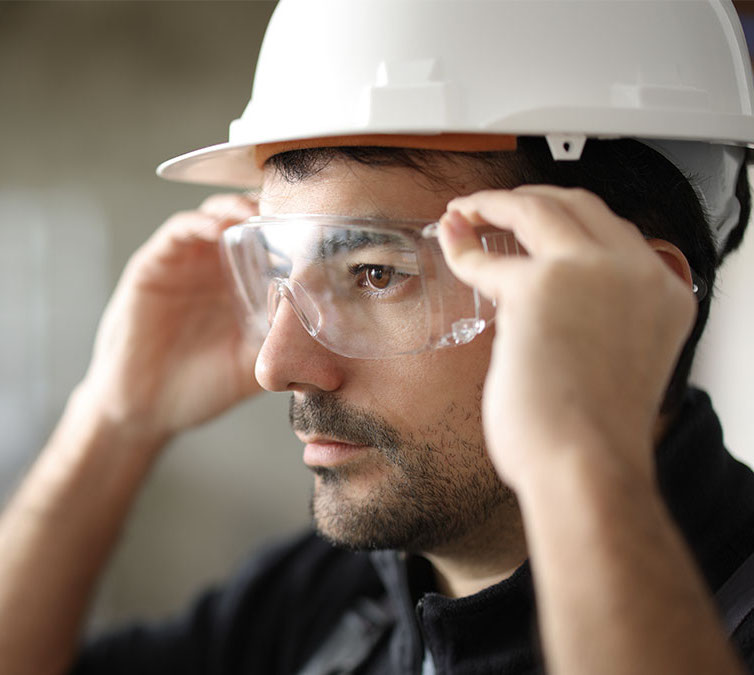 Man wearing safety eyeglasses at a work site